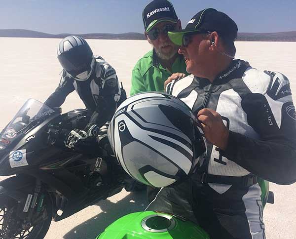 3 motorbikes taking a break and chatting on salt flat